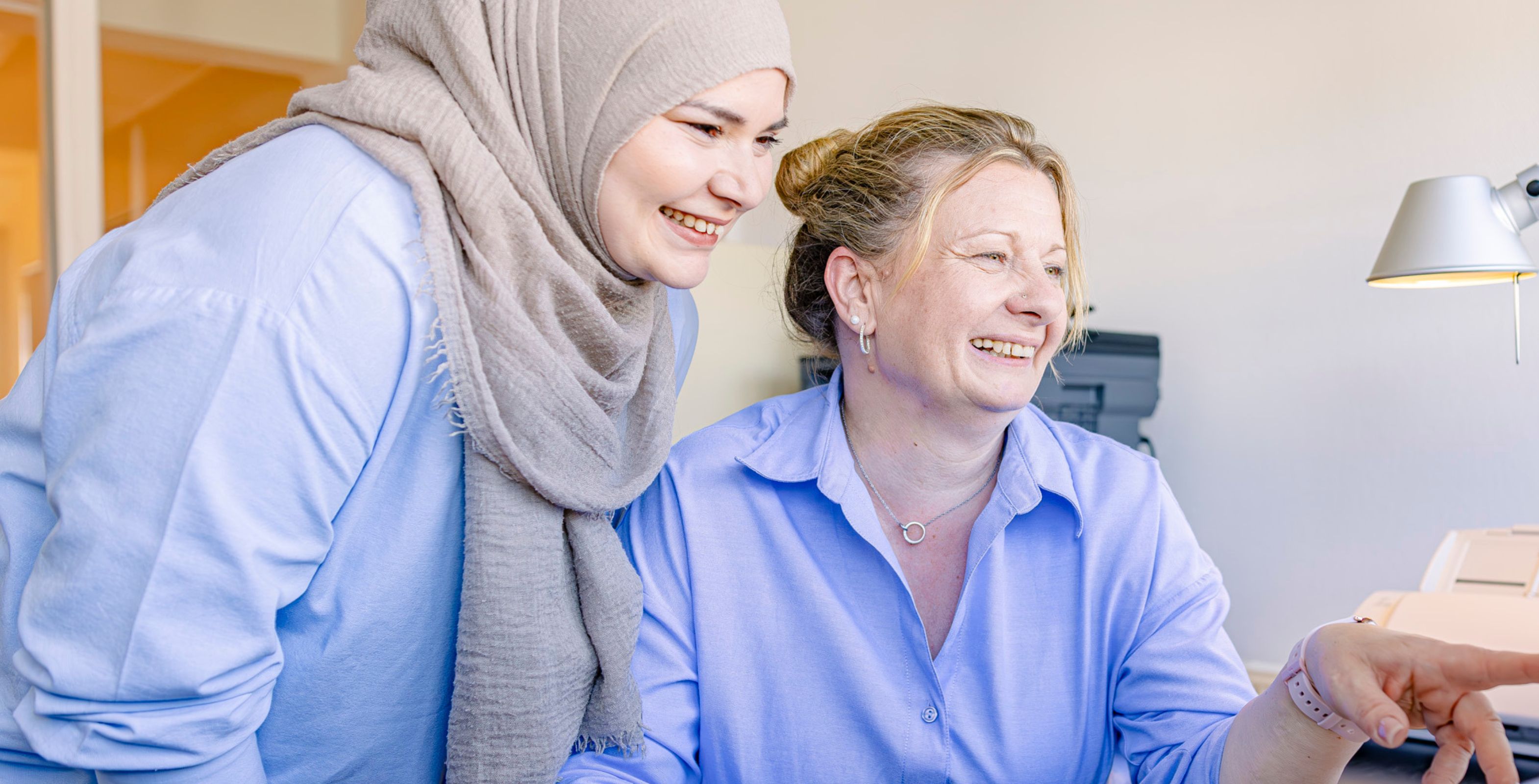 2 Frauen schauen sich gemeinsam etwas am Computer an